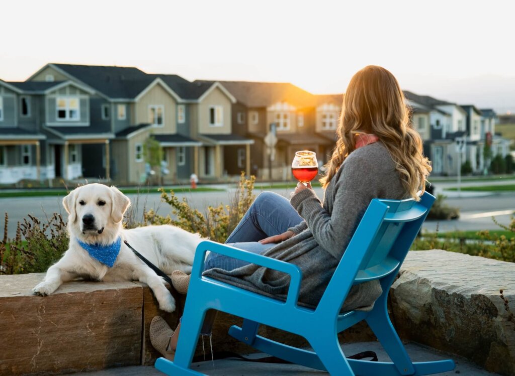 A woman enjoying a beverage alongside her dog.