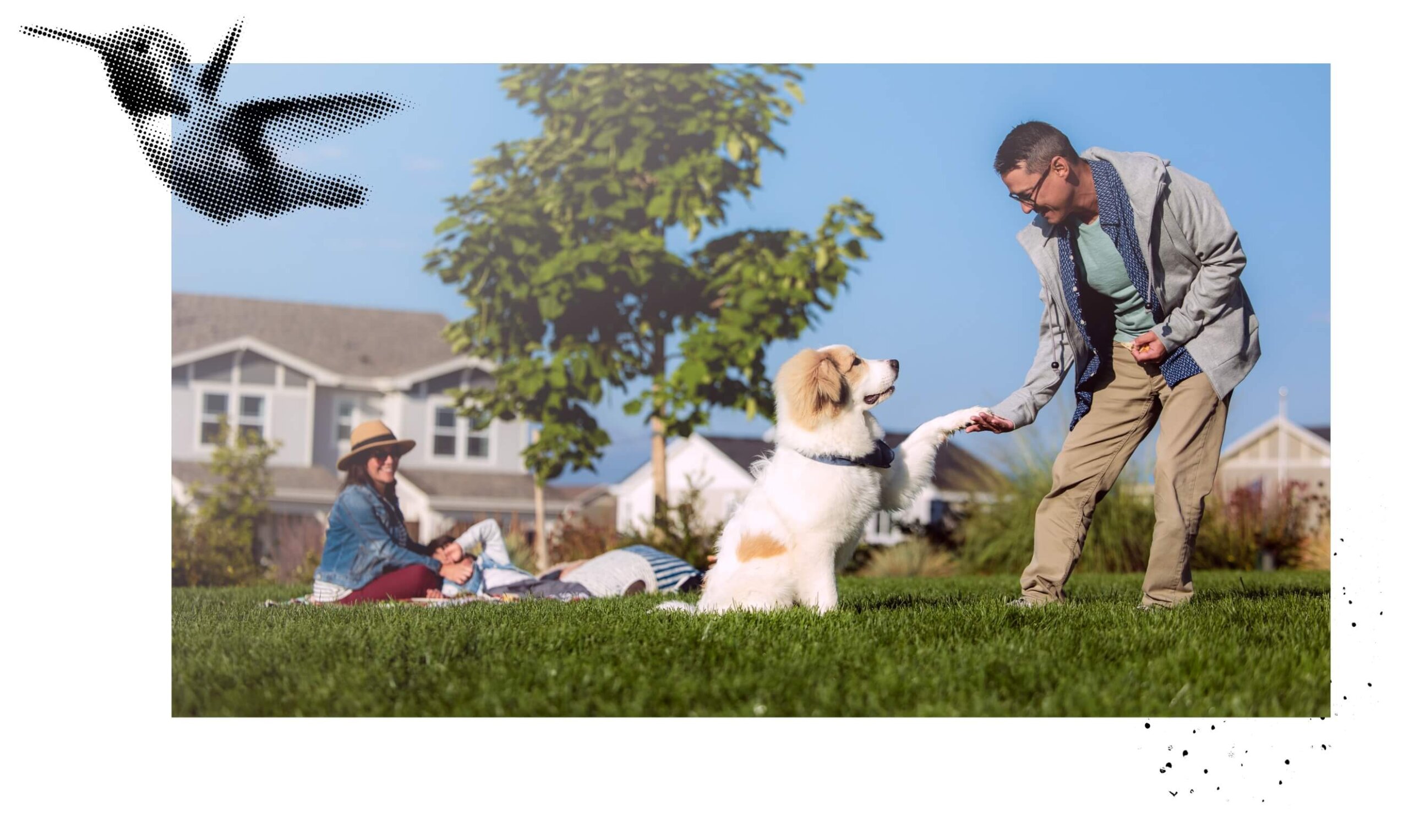 A family in a park next to a man holding a dog's paw.