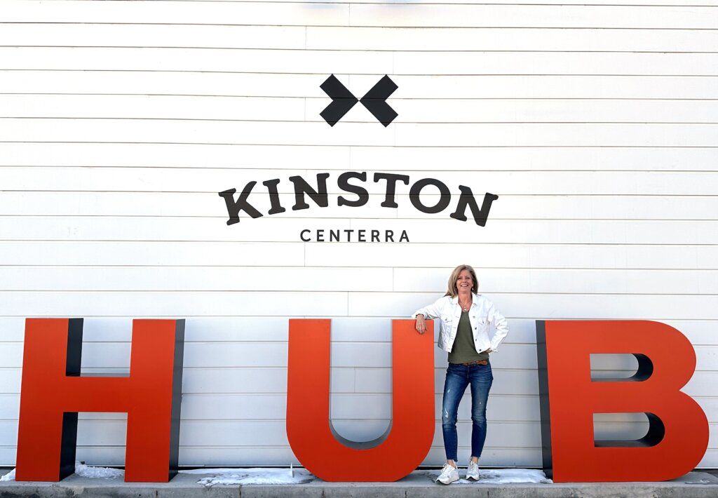 The owner of Hub Café by Fresh Plate posing in front of the Kinston Hub