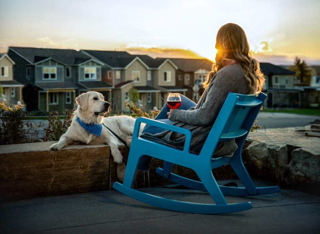 A woman sitting in an adirondack chair with her dog at Kinston