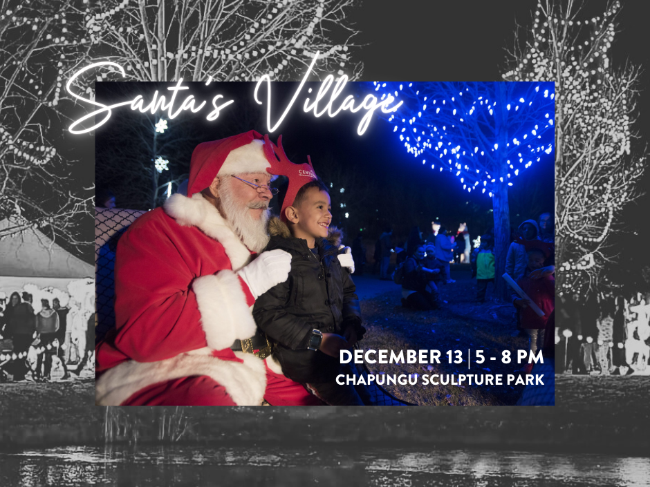 A child gleefully sits with a Santa at Loveland CO's Chapungu Sculpture Park, illuminated by the enchanting blue holiday lights and winter wonderlights. Join us on December 13 from 5-8 PM for Santa's Village and a night filled with festive cheer.